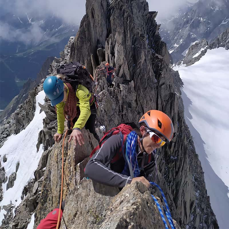 Trois personnes progressent sur une arête.